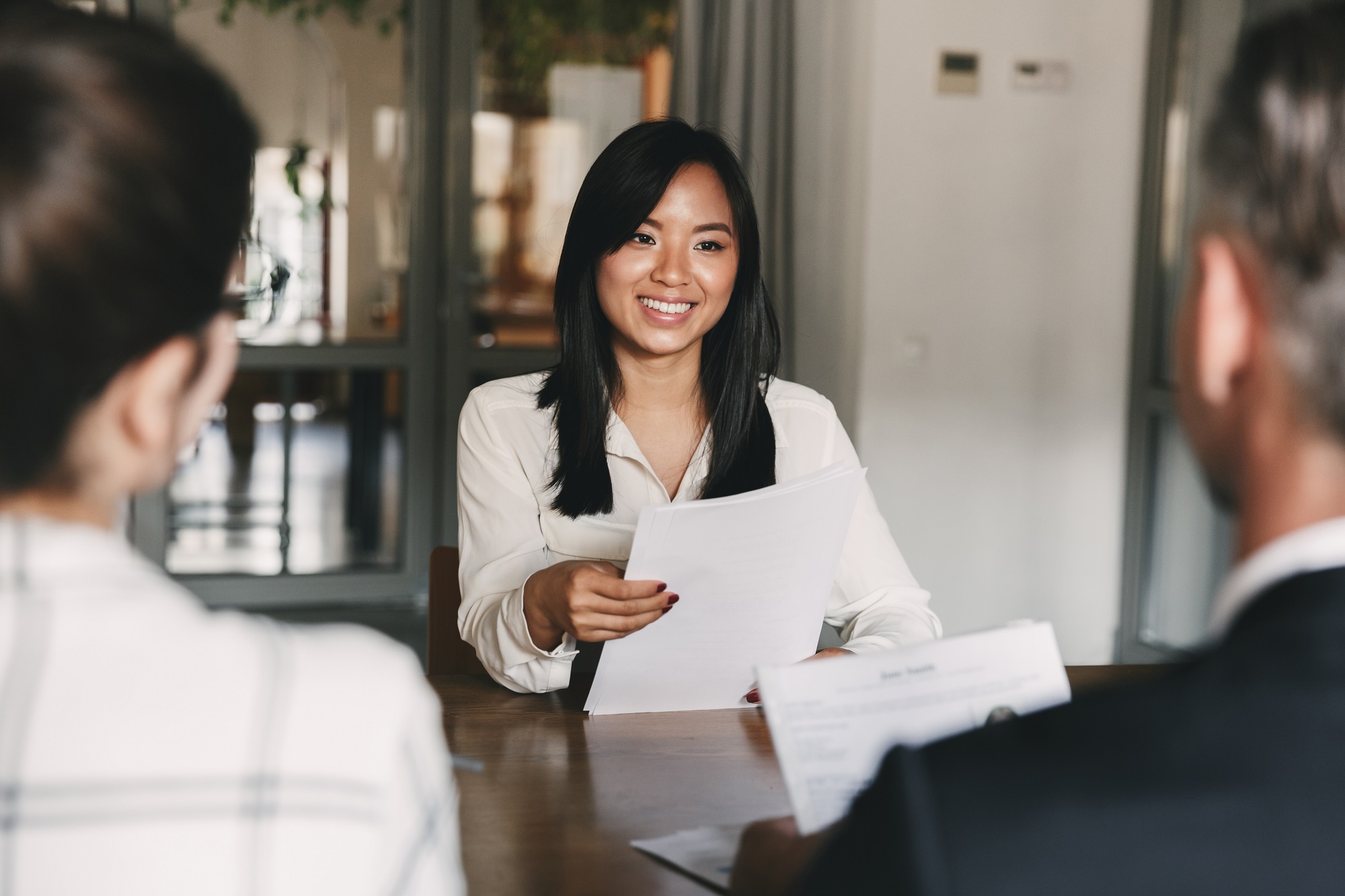 Woman interviewing team members to understand business needs.